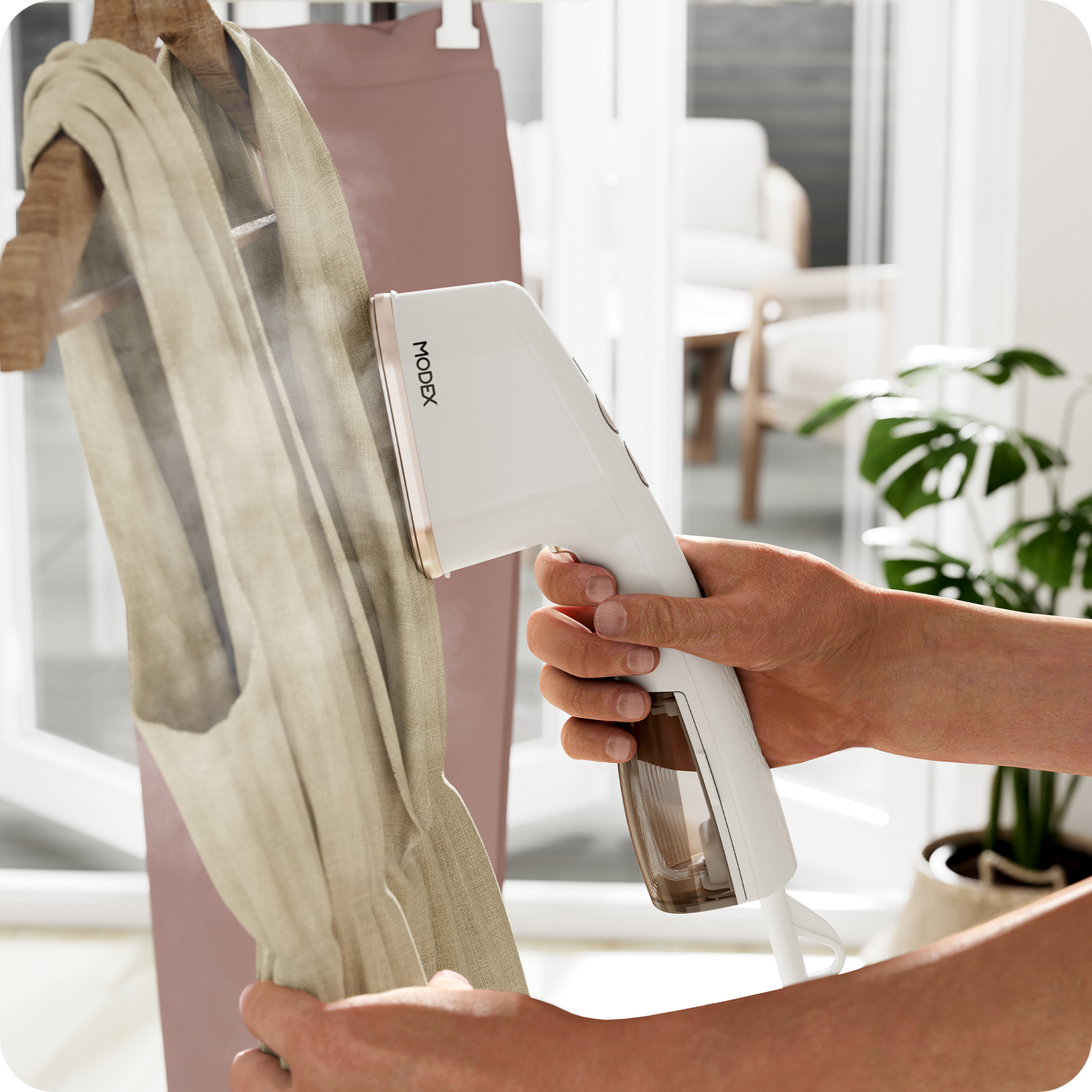 Handheld garment steamer being used vertically on a hanging garment.