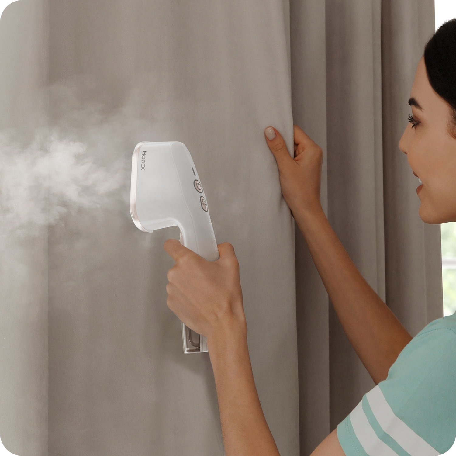 Handheld garment steamer being used on hanging curtains.