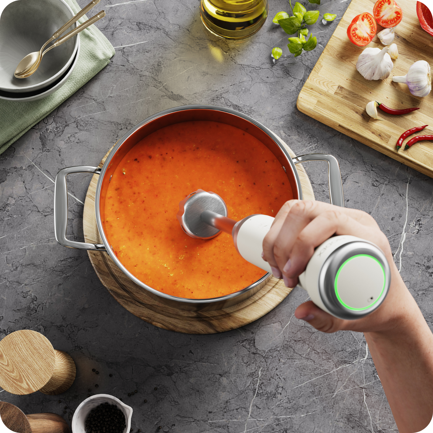Rechargeable hand blender blending hot soup directly inside a cooking pot.