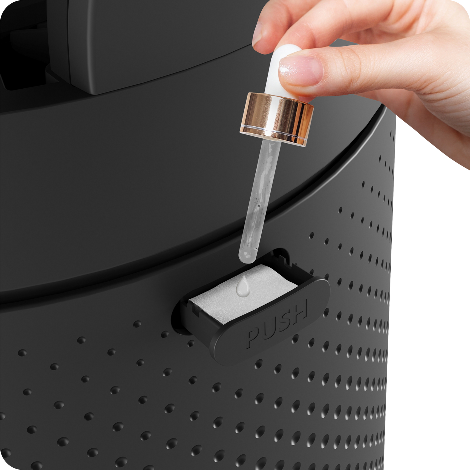 Hand adding aroma oil to the aromatherapy compartment of the MODEX AP1900 air purifier.